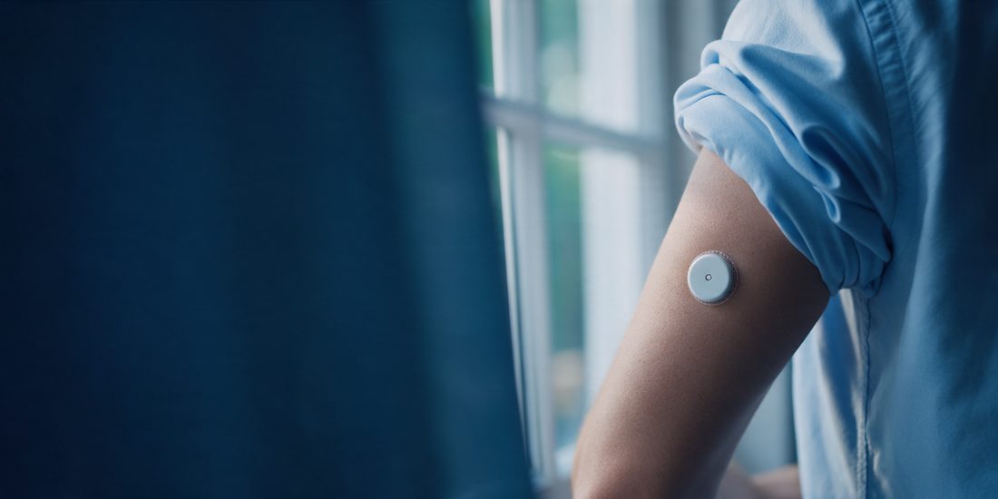 Sensor de monitoreo continuo de glucosa en el brazo de una persona
